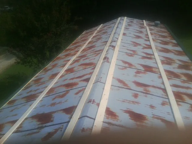 Rusted metal roof panels with new wood purlins before replacement — Storm Damage Roof Repair in North Apollo by Roofing Brothers