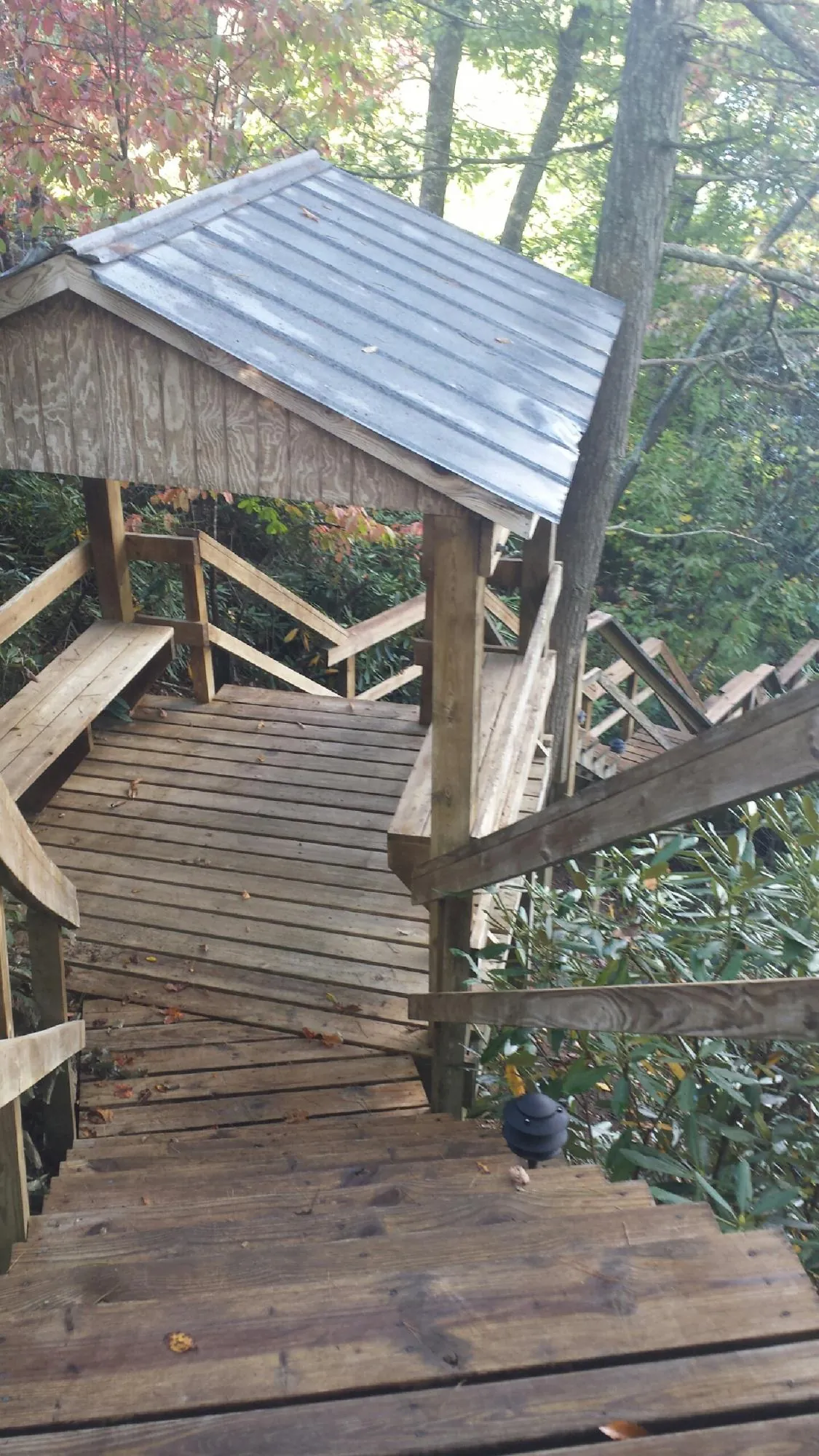Metal roofed shelter over wooden steps on a wooded walkway — Skylight Repair & Installation work by our crew in North Apollo