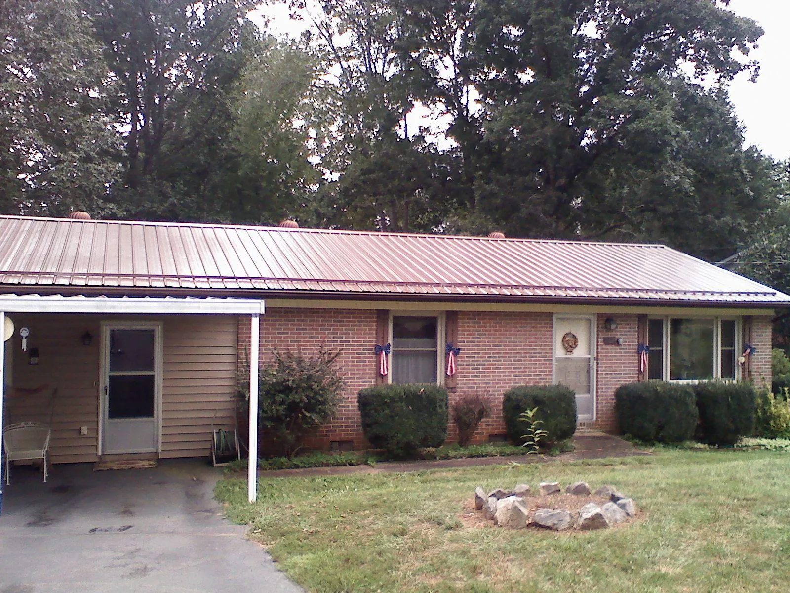Bronze metal roof and carport on a brick ranch home — Roof Repair work by our crew in North Apollo